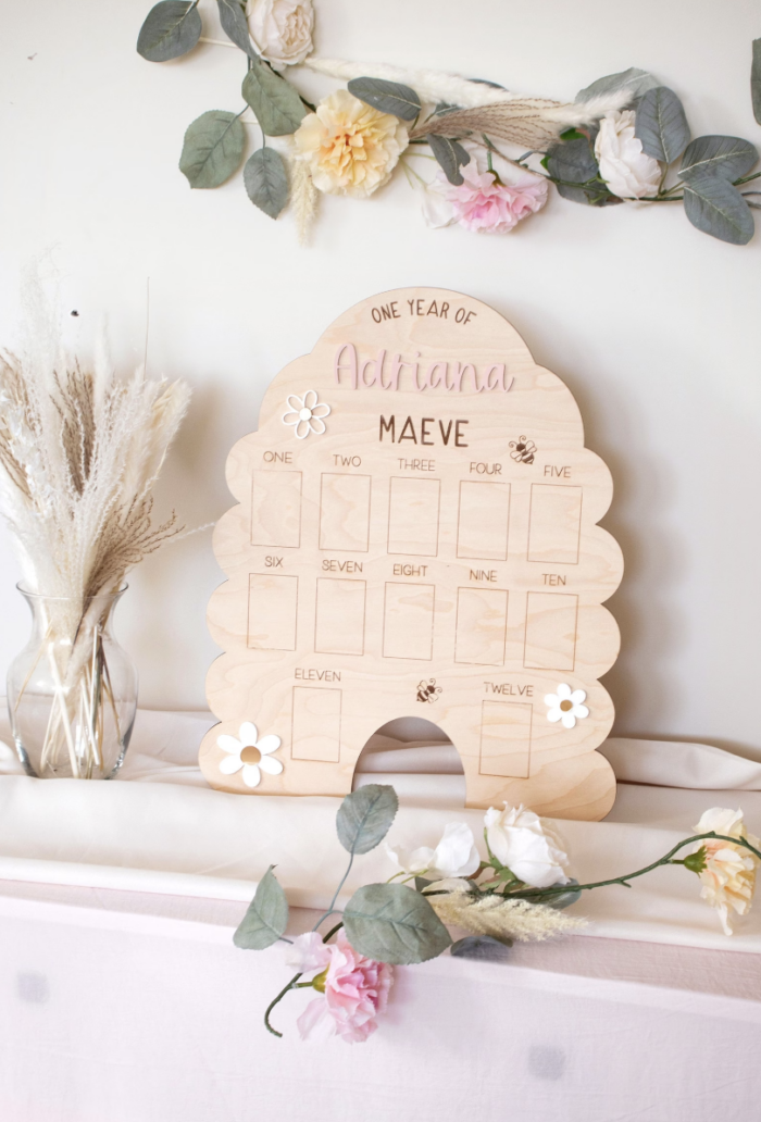 First Bee Day Birthday Party Calendar in the shape of a bee hive on a wall.