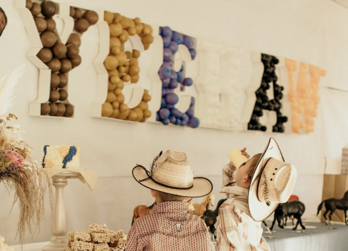 First Rodeo Birthday Party Western style party with two kids at a dessert table.