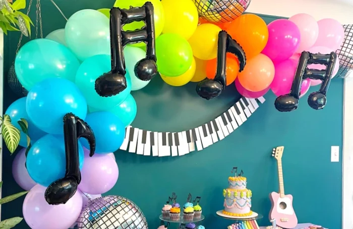 One Hit Wonder Birthday Party Party table with bright balloons and music note balloons.