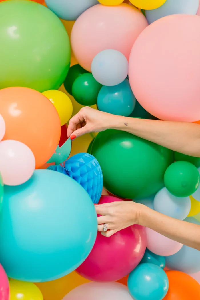 Memory Orb Balloons Balloons on a wall with hands adjusting.