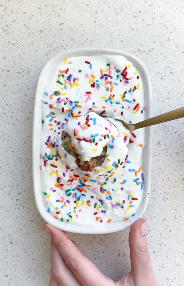 Birthday Brunch Small baking dish with baked oats and sprinkles on top with a spoon taking a bite.