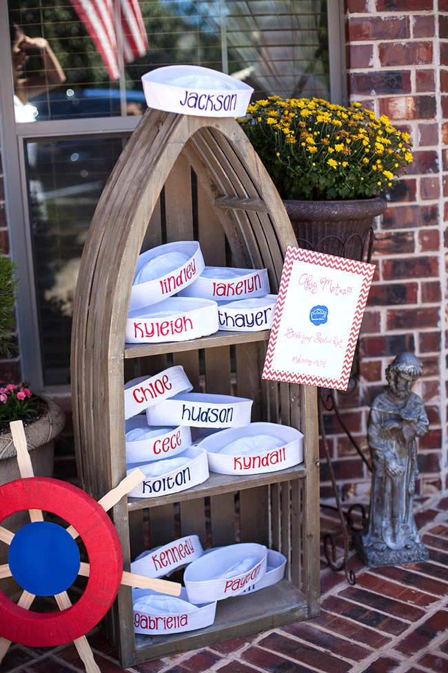 First Mate Birthday Party Boat shaped shelf with customized sailor hats in it.