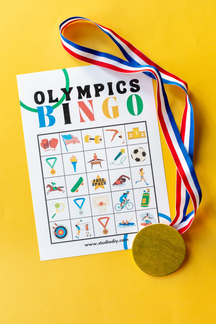 Olympics Bingo PDF Olympics bingo pdf on a yellow background next to a gold medal.
