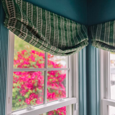 How To Make a Faux Roman Shade roman shade hanging above window in blue painted room