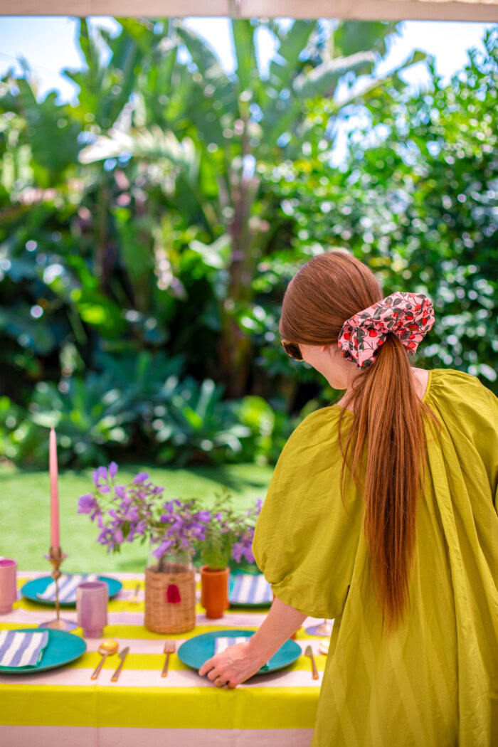 woman wearing oversized scrunchie decorating a table