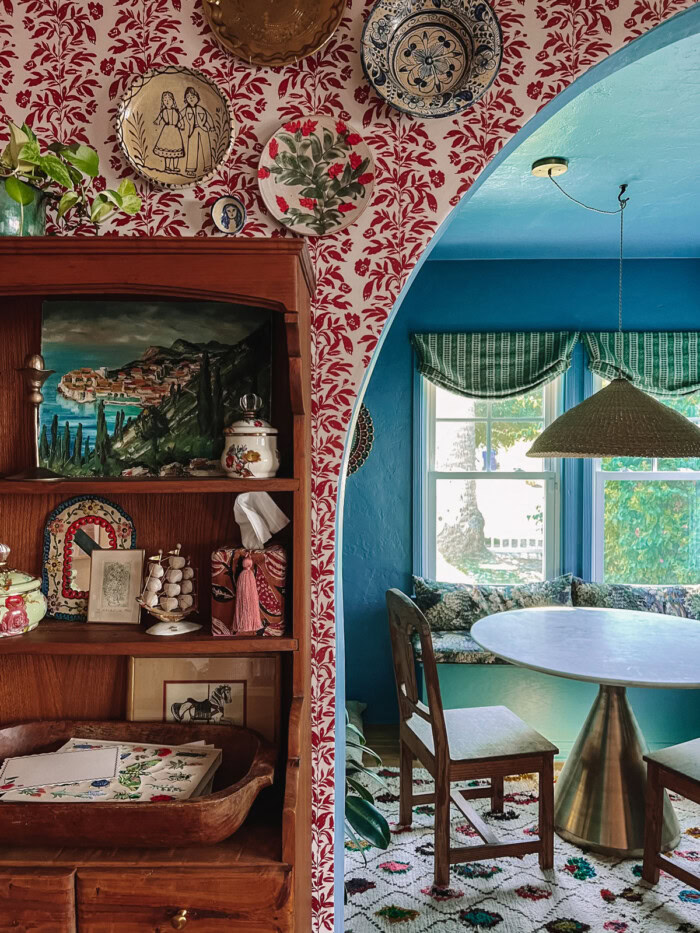 red floral stripe wallpaper with wood hutch and archway